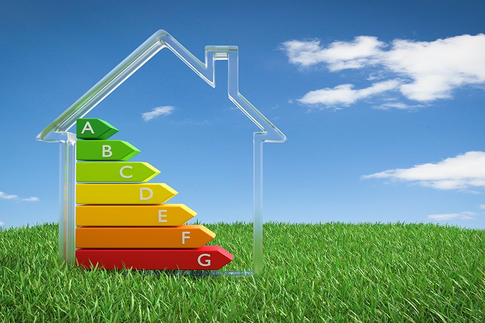 Energy efficiency label placed within a home icon surrounded by greenery and clear sky.